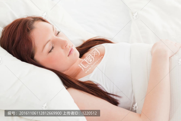 一個可愛的紅發(fā)女孩睡在她的床上