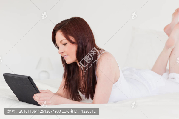 迷人的紅發(fā)女性躺在床上放松自己的藥片