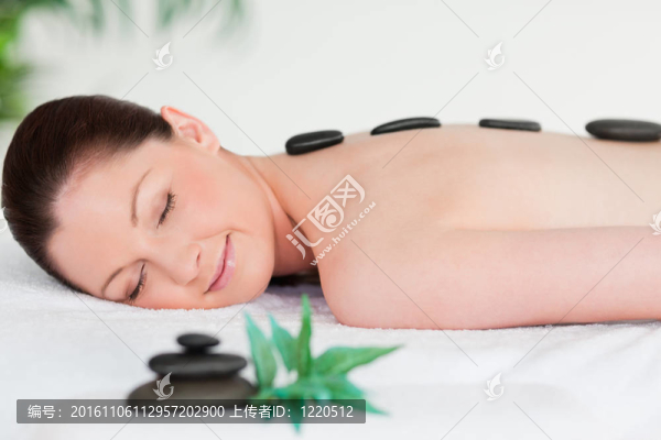 年輕女子用按摩石閉上雙眼