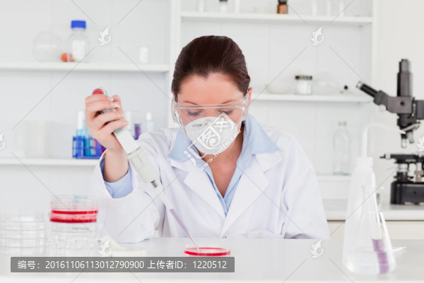 年輕科學(xué)家準(zhǔn)備一個(gè)樣品，同時(shí)戴著保護(hù)面具