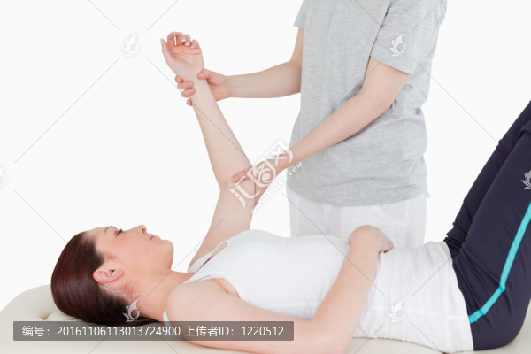 運動員在她的手臂伸展的按摩師