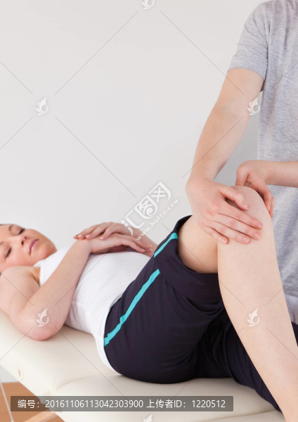 一個(gè)女按摩師集結(jié)一個(gè)年輕女子的膝蓋的肖像