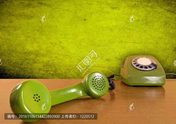 在木制桌子上的綠色電話