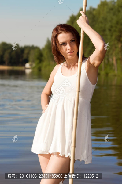 美麗的女人站在湖中。夏天的時間