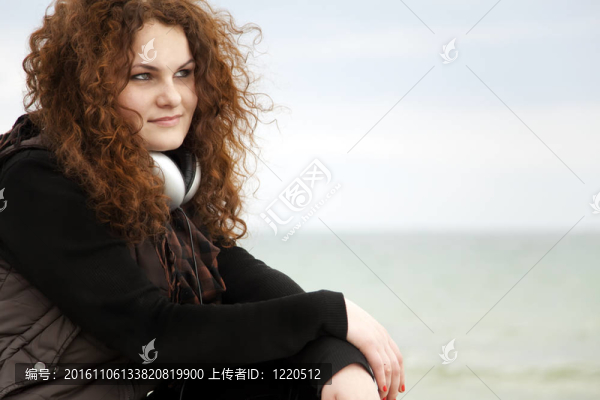 帶耳機(jī)的卷發(fā)紅頭發(fā)女孩。