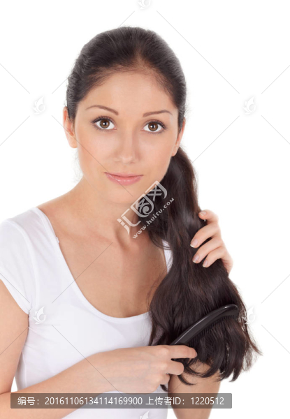 年輕的黑發(fā)美女梳長發(fā)