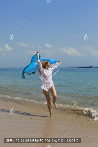 在手舞海角海岸海洋白袍的年輕優(yōu)雅的女人