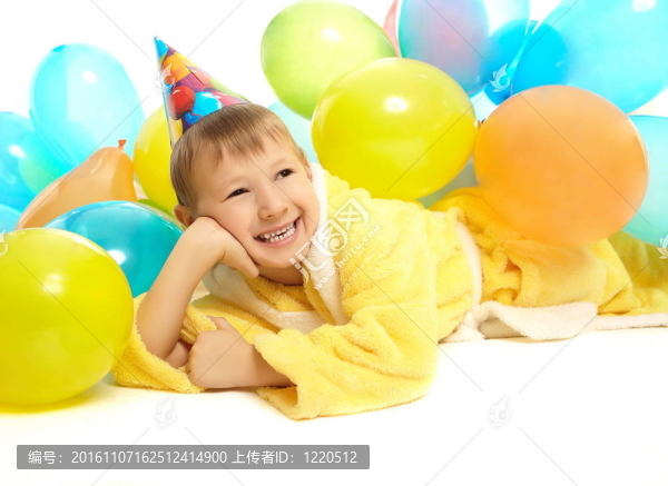 年輕的穿著微笑的小男孩慶祝他的生日，五顏六色的氣球被白色的