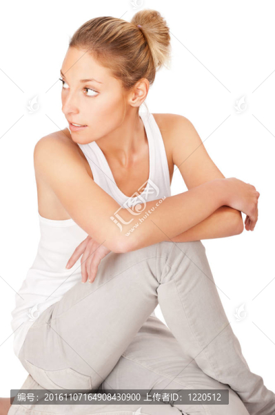 年輕漂亮的女人坐在地板上，孤立在白色背景