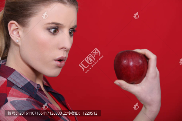 震驚的女人拿著蘋(píng)果