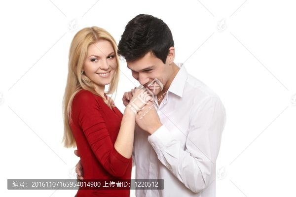 年輕浪漫的英俊男子吻著女孩的手；在白色情人節(jié)微笑的情侶