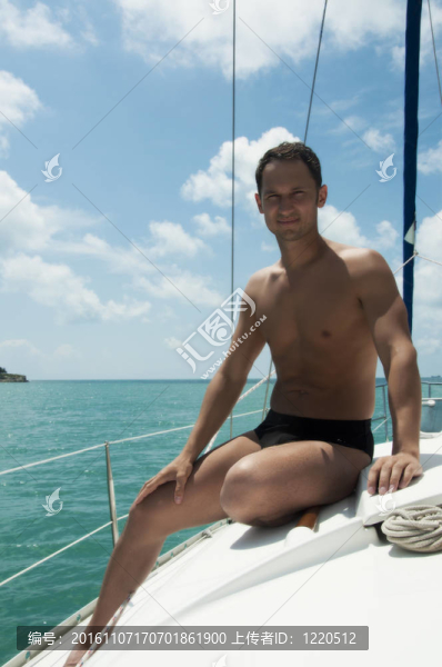 英俊的年輕男子在游艇上航行