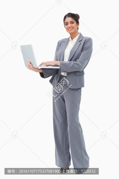 微笑的商人使用筆記本電腦而站