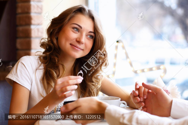 在餐廳里戴著訂婚戒指的年輕夫婦