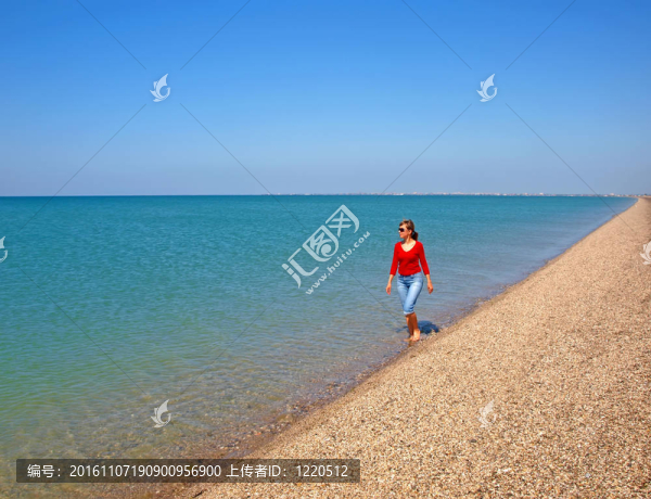 年輕的女人走在海岸線