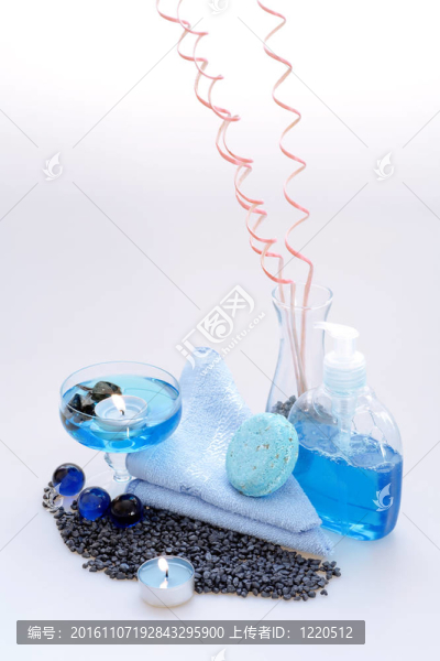 身體護(hù)理液；白色背景的蠟燭和藍(lán)色毛巾