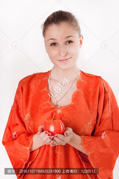 穿橙色衣服的女孩提供了一個紅蘋果