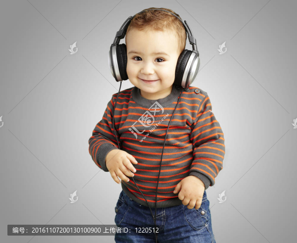 一個(gè)英俊的孩子聽音樂和微笑在G的肖像