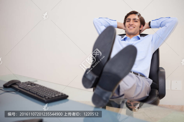 微笑的商人向后靠在椅子上