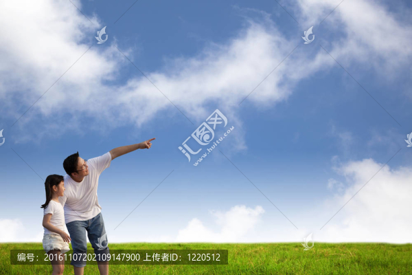草地上的父親和小女孩