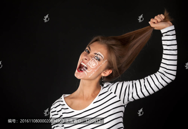 漂亮的女孩穿著條紋連衣裙拉他的頭發(fā)