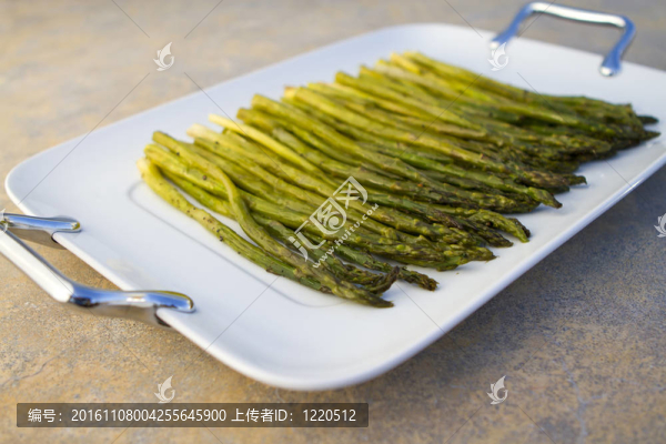 在一個白色的盤子上煮蘆筍