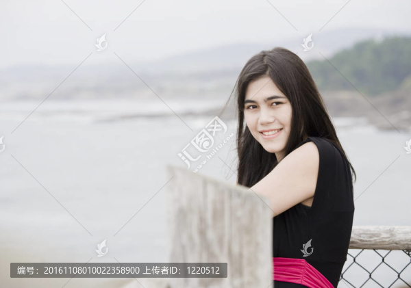 優(yōu)雅的年輕女子或少年站在海邊穿著簡單的黑色連衣裙