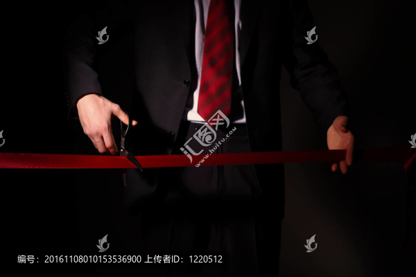 用剪刀切一個紅絲帶的商人