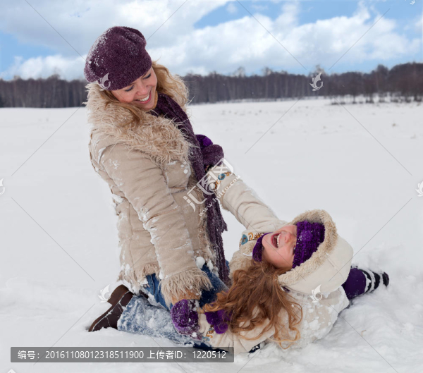 女人和小女孩在雪地里玩