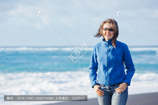 年輕的女人走在藍色的大海。