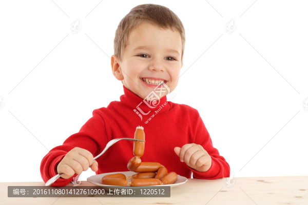 微笑的小男孩在香腸上香腸；白色的隔離