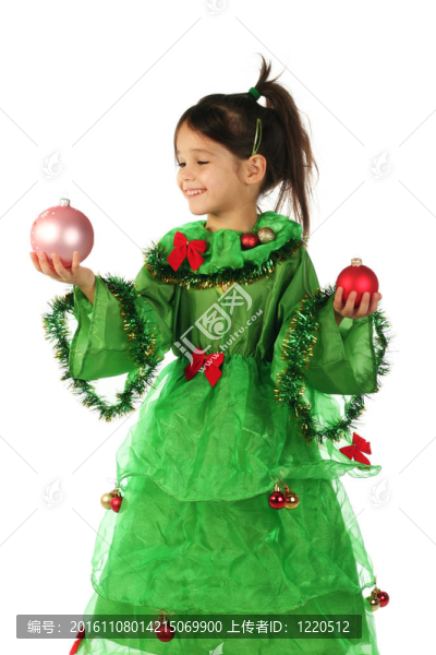 小女孩在綠色圣誕樹(shù)服裝與兩個(gè)圣誕裝飾品