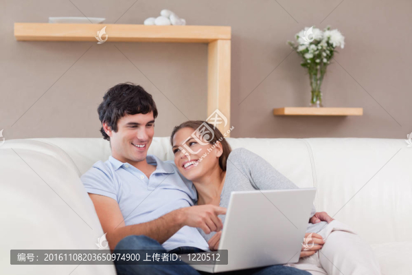 夫婦帶著他們的筆記本在沙發(fā)上