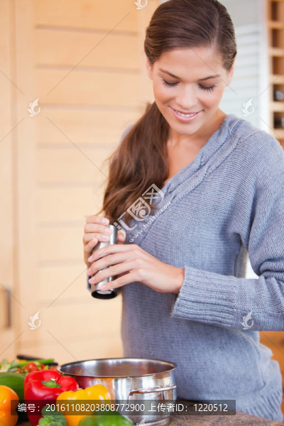 婦女在蔬菜燉菜中加入香料