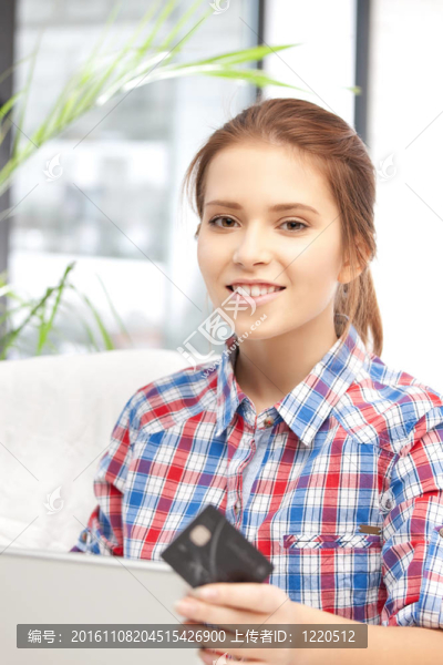 快樂的女人與筆記本電腦和信用卡