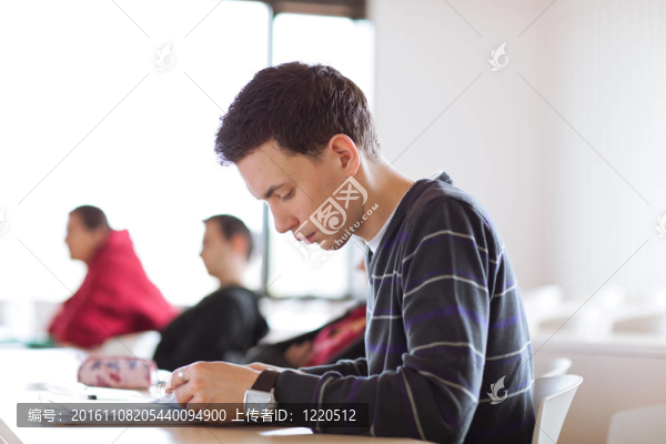 年輕；坐在教室里的英俊男大學(xué)生