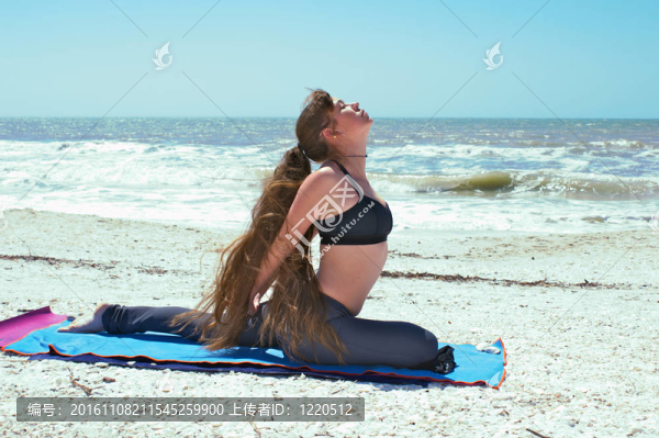 年輕的女人做瑜伽鍛煉對灘肩鴿子式O