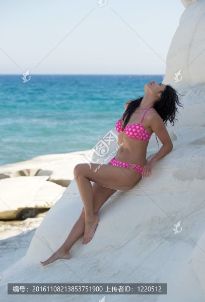 美麗的年輕女子在海灘上放松