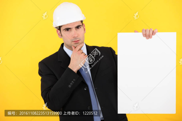 一個(gè)憂郁的建筑師拿著海報(bào)。
