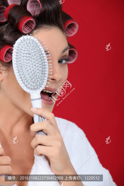 用卷發(fā)器拿著畫筆的女人