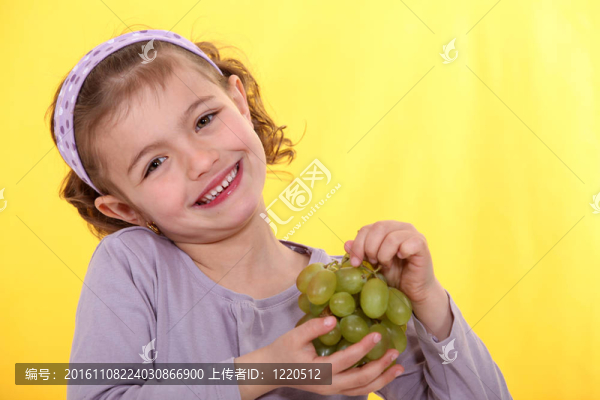 小女孩捧著一串葡萄