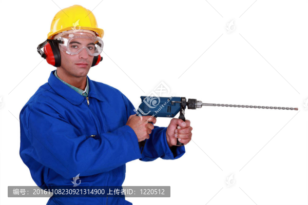 與耳罩和護(hù)目鏡保護(hù)工匠拿著電鉆
