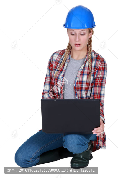 年輕女性建設(shè)者蜷縮著筆記本電腦