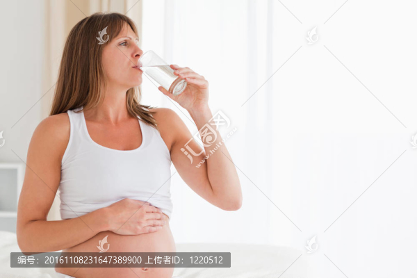 華麗懷孕女性坐在床上吃藥