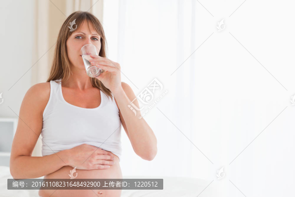 可愛(ài)的懷孕女性坐在床上吃藥
