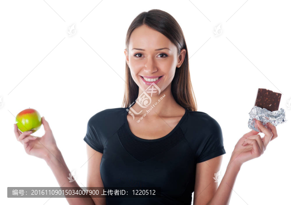 快樂的女孩手里拿著巧克力和蘋果