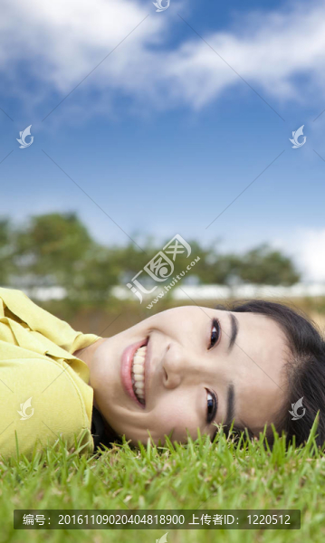 微笑的亞洲年輕女子在草地上