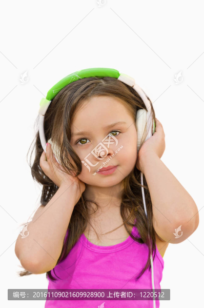 漂亮的小女孩帶著耳機聽音樂
