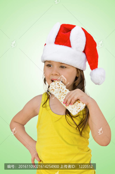 小女孩戴紅色Santa帽吃白巧克力花生