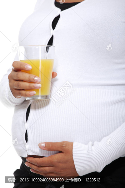 孕婦拿著一杯橙汁